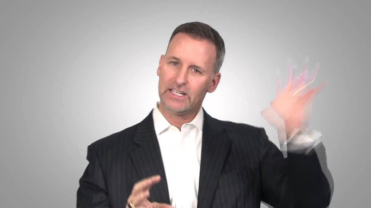 Brian Moran – Productivity Speaker Brian Moran speaking energetically in a business suit, engaging his audience on productivity strategies.